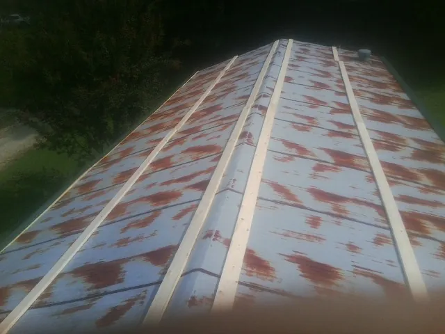 Rusted metal roof panels with new wood purlins before replacement — Storm Damage Roof Repair in District Heights by Roofing Brothers