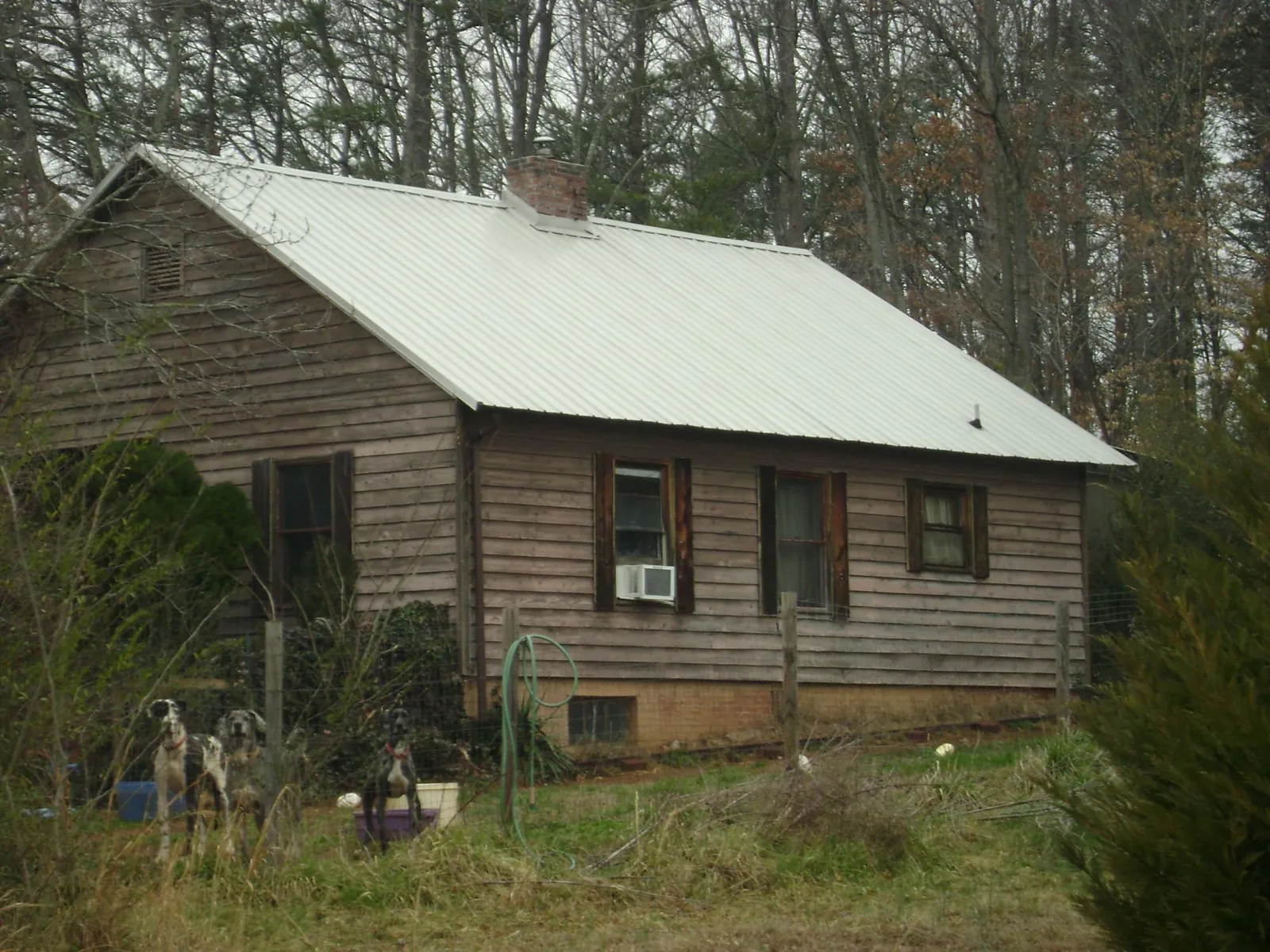 White metal roof on an old wood sided farmhouse, from a Metal Roof Installation job in District Heights